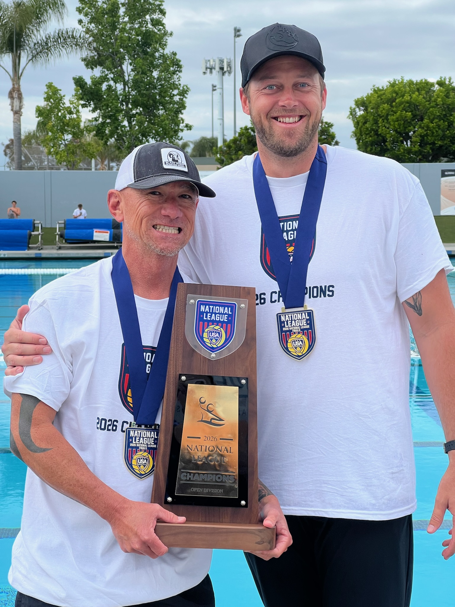 Invictus Aquatics coaches with championship trophy